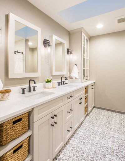 A white bathroom with two sinks and a skylight.