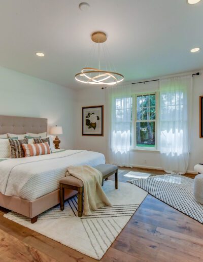 A bedroom with hardwood floors and a bed.
