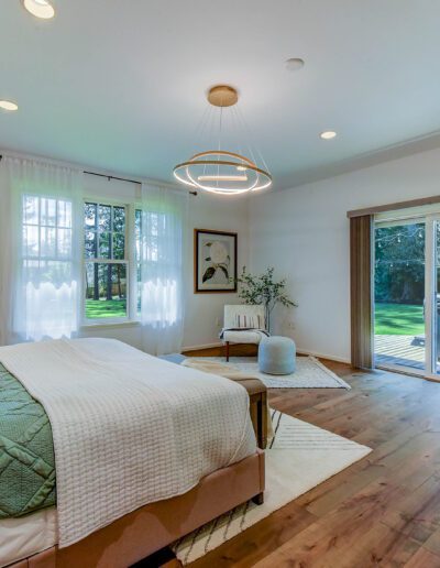 A bedroom with hardwood floors and a sliding glass door.