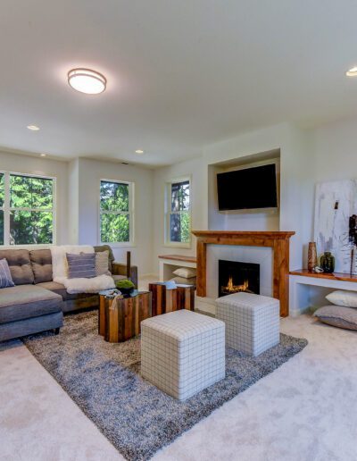 A living room with a fireplace and large windows.